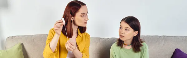 Mother showing menstrual tampons to teenage daughter during sex education at home, horizontal banner — Stock Photo