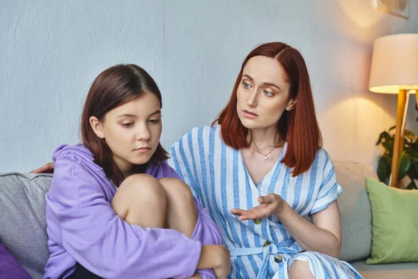 Caring mother talking to frustrated teenage daughter sitting on couch at home, love and support — Stock Photo