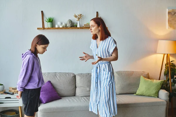 Displeased woman gesturing and quarreling with upset teenage daughter at home, family issues — Stock Photo