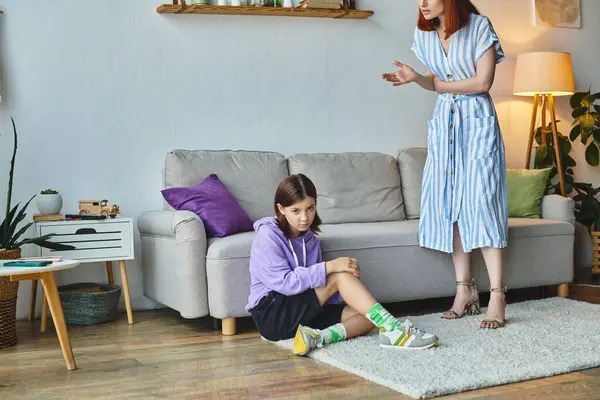 Serious woman talking to frustrated teenage daughter sitting on floor in living room, generation gap — Stock Photo