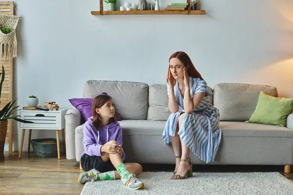 Frustrierte Frau berührt Kopf nahe Teenager-Tochter sitzt auf dem Boden im Wohnzimmer, Konflikt — Stockfoto