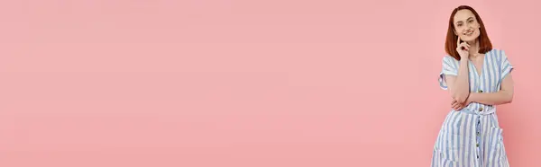 Joyful and fashionable woman in striped dress looking at camera on pink backdrop, horizontal banner — Stock Photo