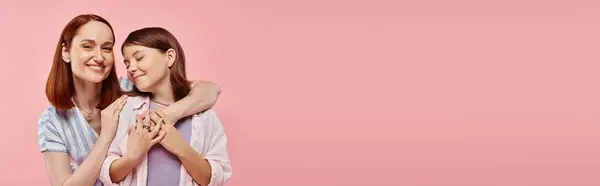 Happy woman embracing teenage girl on pink backdrop, unity of mother and daughter, horizontal banner — Stock Photo