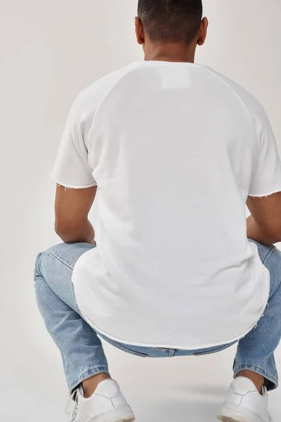 Stylish african american man in trendy casual jeans and white t-shirt, copy space for advertising — Stock Photo