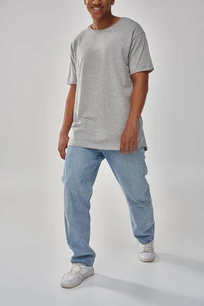 Élégant homme afro-américain en jeans décontractés à la mode et t-shirt gris, espace de copie pour la publicité — Photo de stock