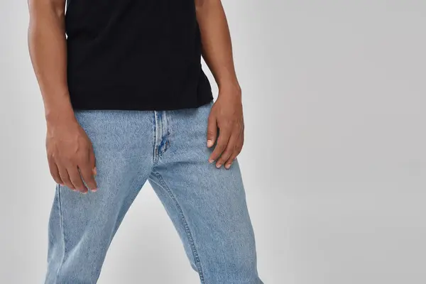Élégant modèle masculin afro-américain posant en t-shirt et jeans noirs, espace de copie pour la publicité — Photo de stock