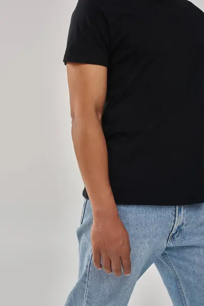 Modelo masculino afroamericano elegante posando en camiseta negra y pantalones vaqueros, espacio de copia para la publicidad - foto de stock