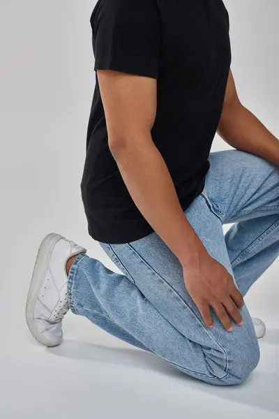 Стильна афроамериканська чоловіча модель позує в чорній футболці і джинсах, копіює простір для реклами — стокове фото