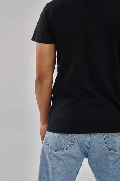 Elegante modelo masculino afro-americano posando em camiseta preta e jeans, espaço de cópia para publicidade — Fotografia de Stock