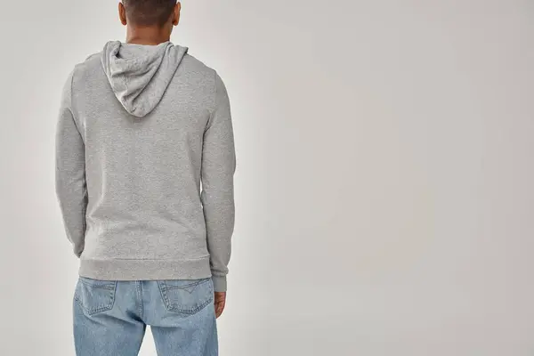 Hombre afroamericano con estilo en sudadera casual gris y jeans, espacio de copia para la publicidad - foto de stock