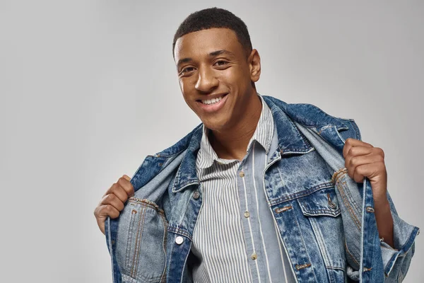 Handsome emotional african american man in denim outfit posing on white backdrop, fashion concept — Stock Photo