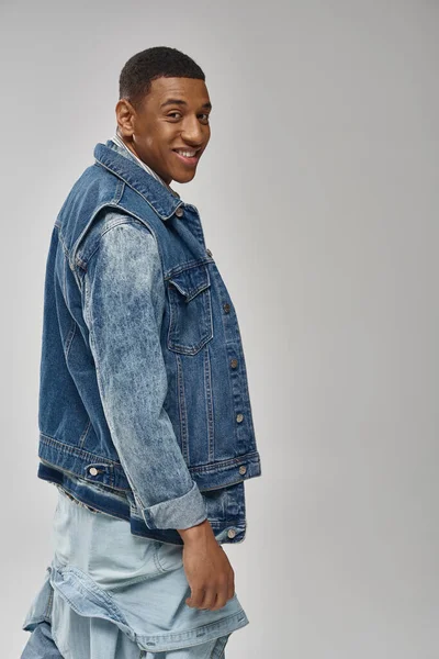 Handsome emotional african american man in denim outfit posing on white backdrop, fashion concept — Stock Photo