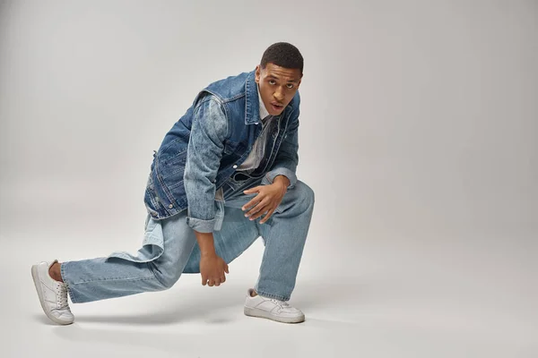 Schöner emotionaler afrikanisch-amerikanischer Mann im Jeans-Outfit posiert auf weißem Hintergrund, Modekonzept — Stockfoto