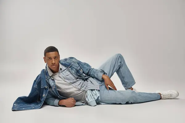 Attractive emotional african american man in stylish denim outfit posing in motion, fashion concept — Stock Photo
