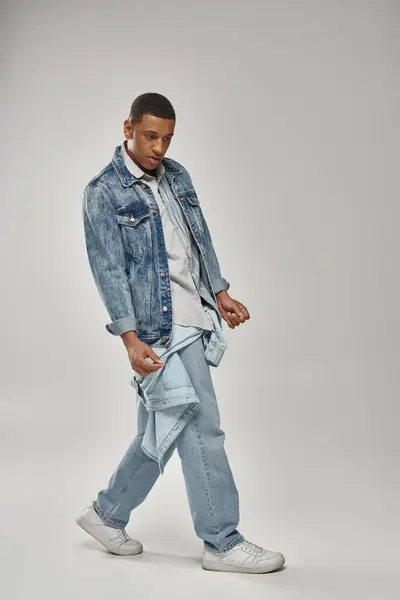 Jovem homem americano africano na moda em roupa de ganga elegante posando em pano de fundo branco, moda — Fotografia de Stock