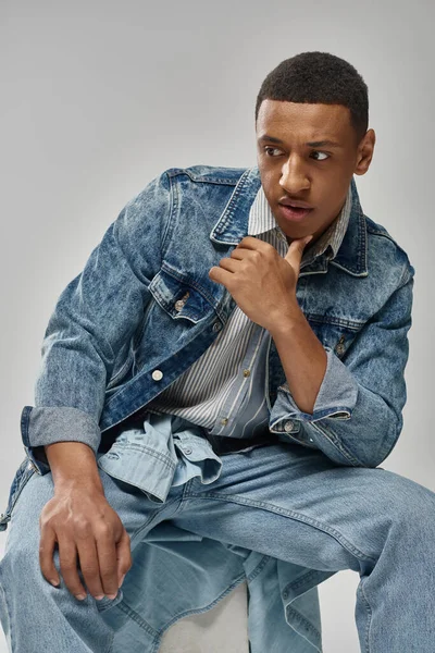 Junge trendige afrikanisch-amerikanische Mann in stilvollem Jeans-Outfit posiert auf weißem Hintergrund, Mode — Stockfoto