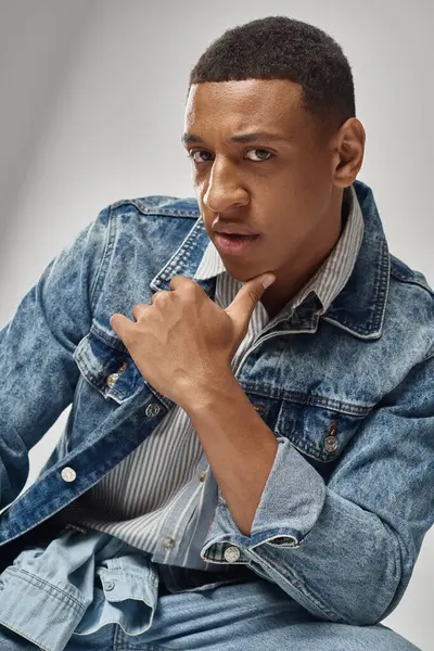 Young trendy african american man in stylish denim outfit posing on white backdrop, fashion — Stock Photo