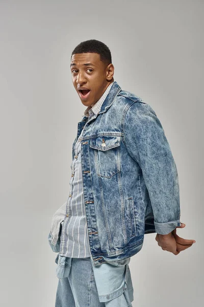 Shocked emotional african american man in stylish denim outfit gesturing lively, fashion concept — Stock Photo