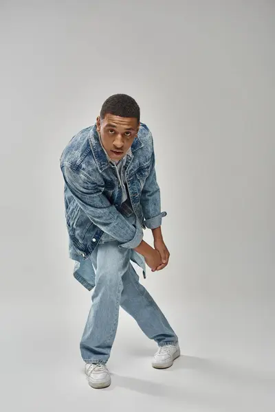 Attractive emotional african american man in stylish denim outfit gesturing lively, fashion concept — Stock Photo