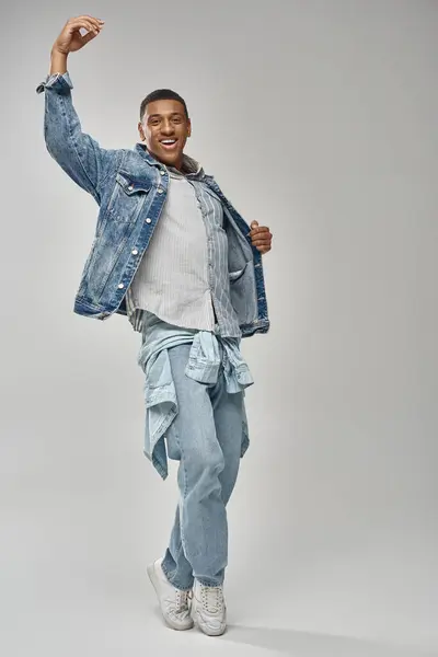 Atractivo hombre afroamericano emocional en traje de mezclilla elegante gesto animado, concepto de moda - foto de stock