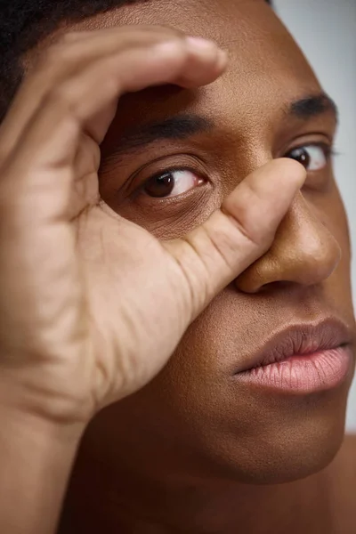 Close up of handsome appealing african american man with hand in front of face, fashion concept — Stock Photo