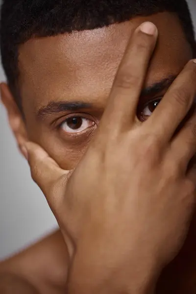 Close up of handsome appealing african american man with hand in front of face, fashion concept — Stock Photo