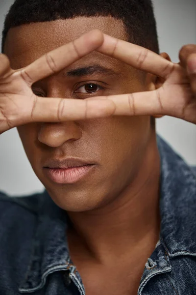 Portrait of stylish african american man in denim attire gesturing at camera, fashion concept — Stock Photo