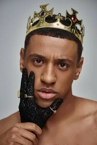 Female hands in black gloves with rings near face of shirtless african american man with crown — Stock Photo
