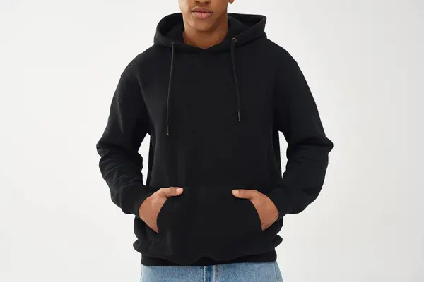 Trendiges afrikanisch-amerikanisches Männermodel in lässigem schwarzen Kapuzenpulli und Jeans, Kopierfläche für Werbung — Stockfoto