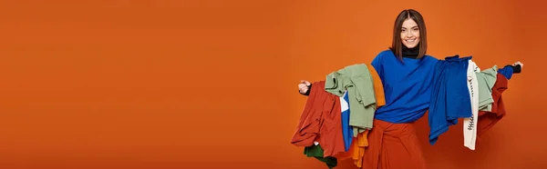 Happy woman with brunette short hair holding colorful autumnal clothes,  black friday banner — Stock Photo