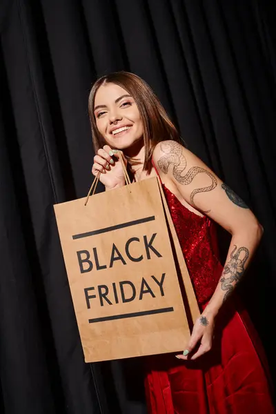 Mulher atraente com piercing e tatuagens com compras de volta nas mãos, conceito de sexta-feira preta — Fotografia de Stock