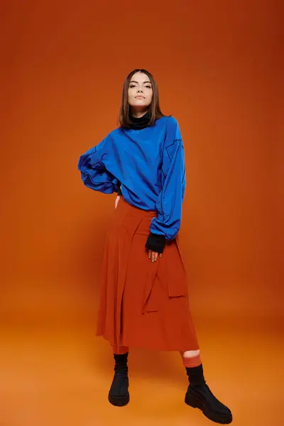 Attraente giovane modello femminile indossa giacca blu casual e gonna arancione con la mano sul fianco — Foto stock