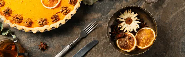 День благодарения украшенный тыквенный пирог возле винтажных столовых приборов, апельсиновые ломтики и травы со специями, баннер — стоковое фото