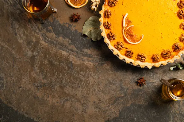 Deliciosa torta de abóbora com nozes e fatias de laranja perto de chá quente, ação de graças outonal ainda vida — Fotografia de Stock