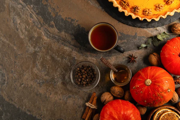 Warm tea and honey near aromatic spices, ripe gourds and delicious pumpkin pie, thanksgiving treats — Stock Photo