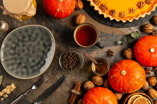 Thanksgiving setting with ceramic plate, ripe gourds and pumpkin pie near autumnal festive objects — Stock Photo
