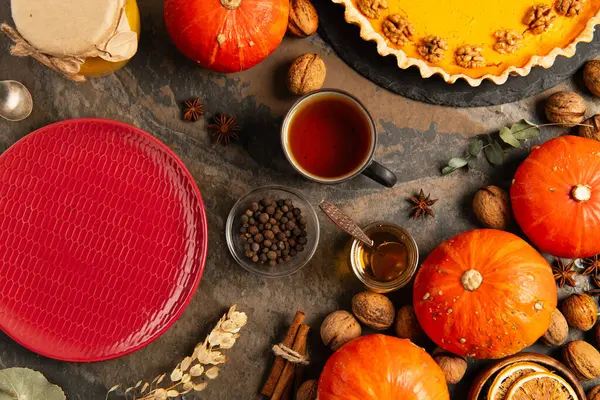 Oggetti autunnali colorati di ringraziamento, piatto di ceramica rossa vicino alle zucche arancioni e torta di zucca — Foto stock