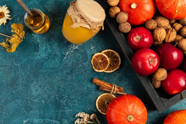 Tema de acción de gracias, la cosecha de otoño cerca de frascos con miel y especias aromáticas en la mesa de textura azul - foto de stock