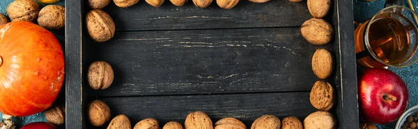Барвистий день подяки фон з волоськими горіхами на чорному дерев'яному лотку біля падаючих предметів, банер — стокове фото