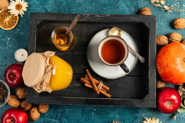 Fundo de ação de graças, bandeja de madeira preta com chá de ervas e mel perto de objetos de colheita outonal — Fotografia de Stock