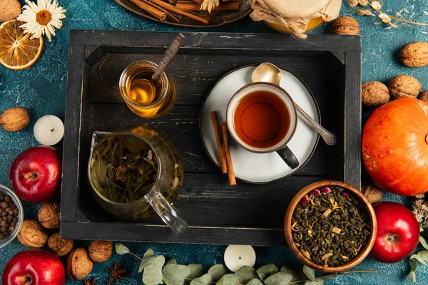 Conceito de ação de graças, bandeja de madeira preta com chá de ervas e mel perto de objetos de colheita coloridos — Fotografia de Stock