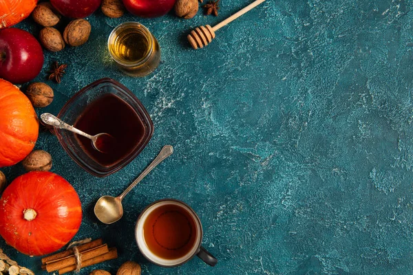 Warmer Tee und Honig-Ahornsirup in der Nähe von Kürbissen und Herbsternte auf blau strukturiertem Tisch, Danksagung — Stockfoto
