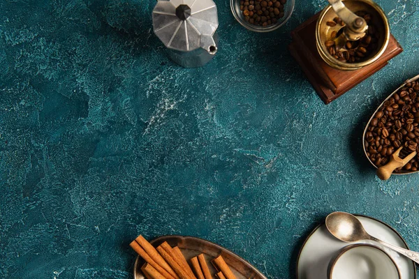 Broyeur manuel avec grains de café près bâtonnets de cannelle sur table texturée bleue, matin d'Action de grâces — Photo de stock