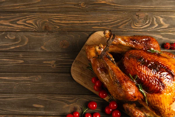 Erntedank-Abendessen, köstlich gebratener Truthahn in der Nähe reifer roter Kirschtomaten auf rustikalem Holztisch — Stockfoto