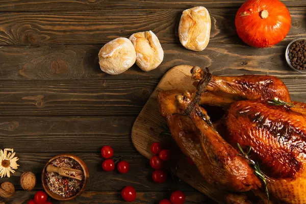Erntedank-Truthahn und frisch gebackenes Brot neben Kirschtomaten und Kürbis auf rustikalem Holztisch — Stockfoto