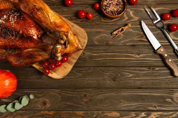 Composizione di cibo per il Ringraziamento, tacchino arrosto con spezie e pomodorini rossi su tavola di legno — Foto stock