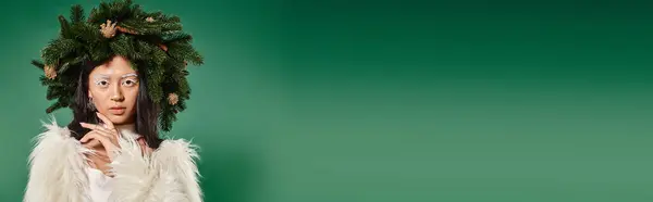 Bannière de femme en fausse veste de fourrure et couronne naturelle sur la tête en regardant la caméra sur fond vert — Photo de stock