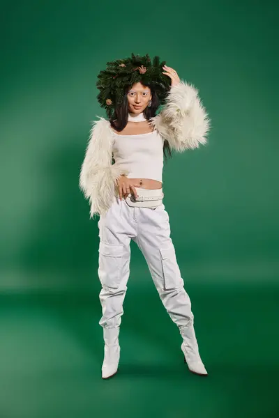 Moda de férias, mulher bonita com maquiagem branca e roupa na moda posando em grinalda em pano de fundo verde — Fotografia de Stock