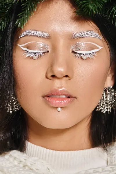 Зимняя красота, крупным планом азиатская женщина с белым макияжем глаза и бусы на лице позируя в венке — стоковое фото