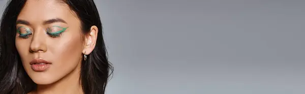 Retrato de hermosa mujer asiática con cabello moreno, maquillaje de ojos brillantes y ojos cerrados, pancarta - foto de stock